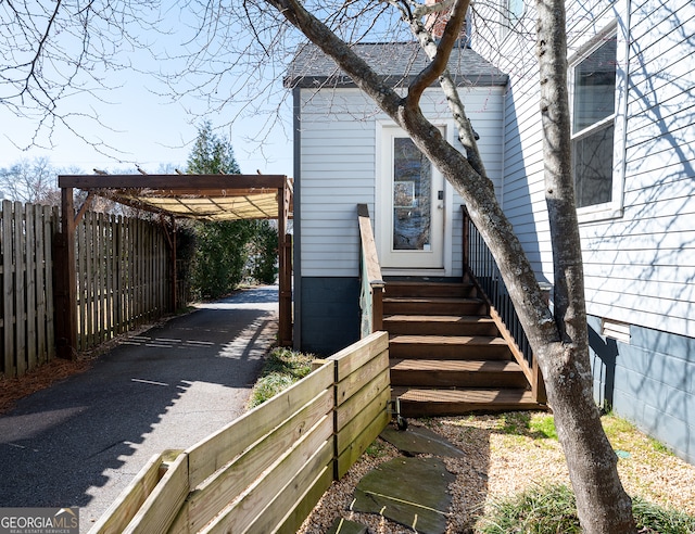 view of home's exterior with entry steps, crawl space, fence, a carport, and driveway