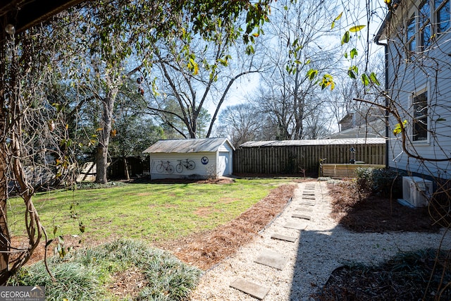 view of yard featuring a storage unit, an outdoor structure, and fence