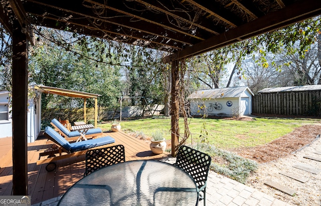 view of patio with a fenced backyard, an outdoor structure, a wooden deck, a shed, and outdoor dining space