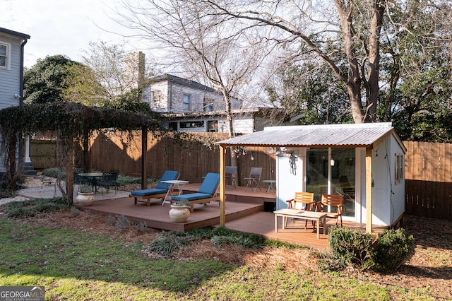 exterior space with a fenced backyard, a deck, and an outdoor structure