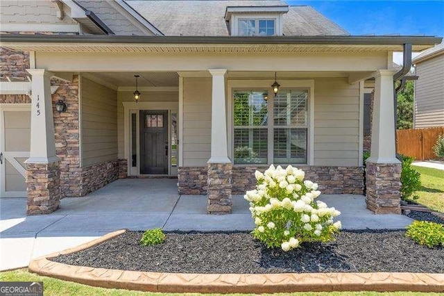 entrance to property featuring a porch and stone siding