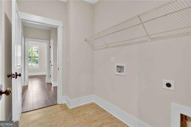 clothes washing area featuring hookup for an electric dryer, washer hookup, laundry area, baseboards, and wood finished floors