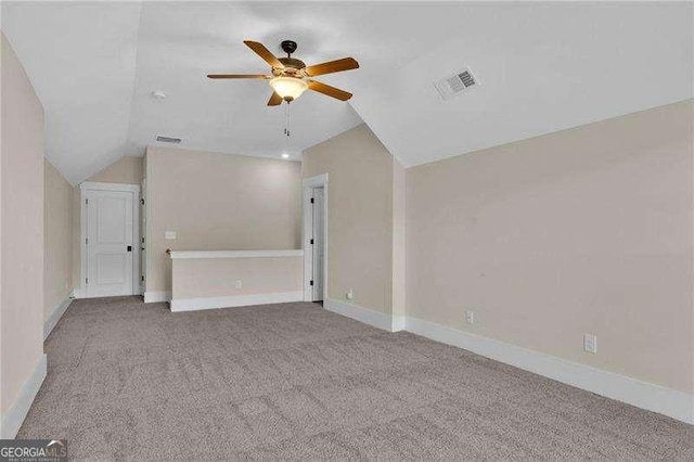 interior space featuring carpet, visible vents, a ceiling fan, and vaulted ceiling