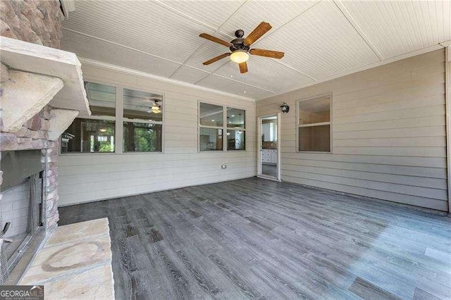 exterior space with a large fireplace and a ceiling fan