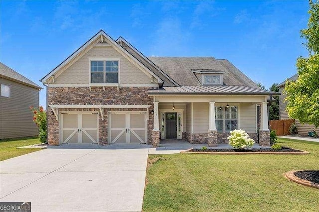 craftsman house featuring a standing seam roof, a front yard, driveway, and stone siding