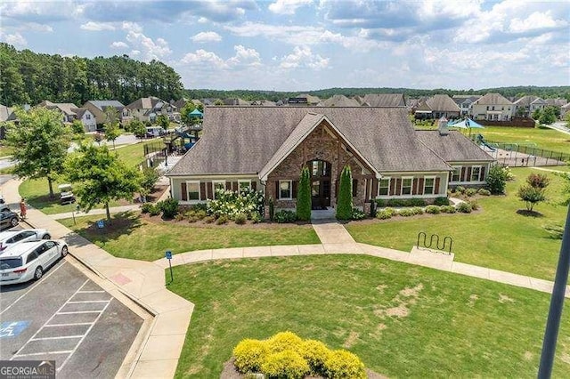 tudor house with a front yard, uncovered parking, brick siding, and a residential view