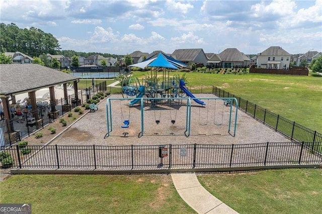 community playground with a residential view, a yard, and fence