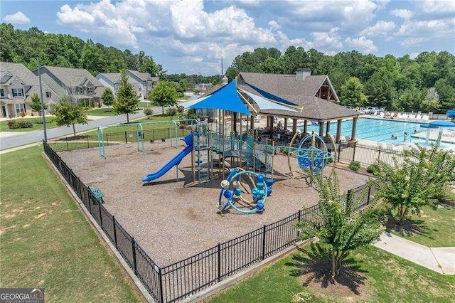 community jungle gym with fence and a yard