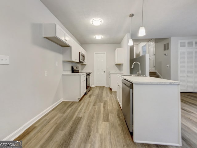 170 Pinehurst Dr, Stockbridge, GA 30281 - kitchen featuring appliances with stainless steel finishes, light wood-type flooring, light countertops, and white cabinets