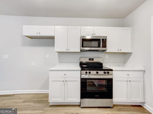 170 Pinehurst Dr, Stockbridge, GA 30281 - kitchen featuring stainless steel appliances, white cabinets, light wood-type flooring, and light countertops