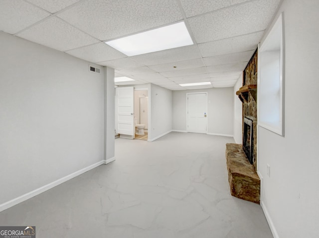 basement featuring a fireplace and a paneled ceiling