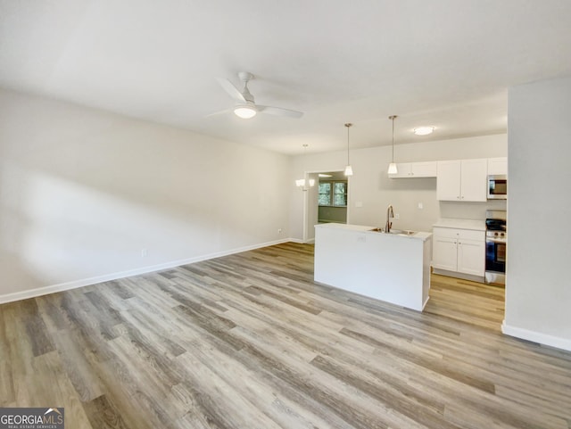 kitchen featuring a center island with sink, appliances with stainless steel finishes, sink, light hardwood / wood-style flooring, and white cabinetry