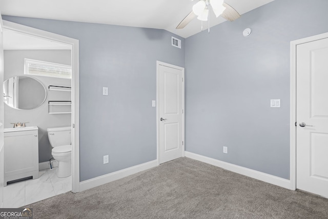 unfurnished bedroom featuring visible vents, vaulted ceiling, a sink, and baseboards