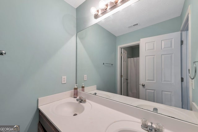 full bathroom featuring a sink, double vanity, and visible vents