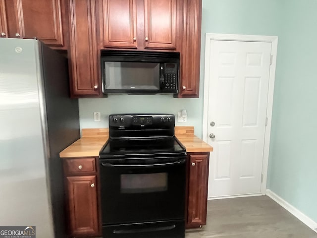 kitchen with baseboards, light countertops, and black appliances