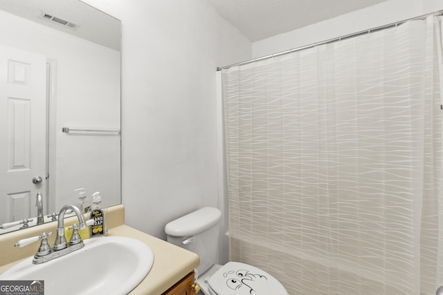 bathroom with a textured ceiling, toilet, vanity, and a shower with curtain