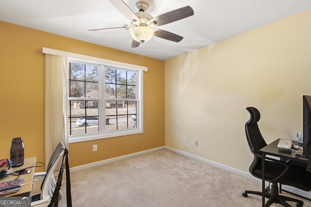 home office with a textured ceiling, ceiling fan, and light colored carpet