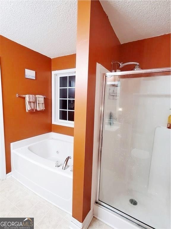 bathroom featuring a textured ceiling, independent shower and bath, and tile patterned floors