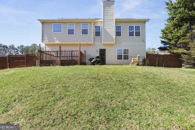 rear view of house featuring a lawn and a wooden deck