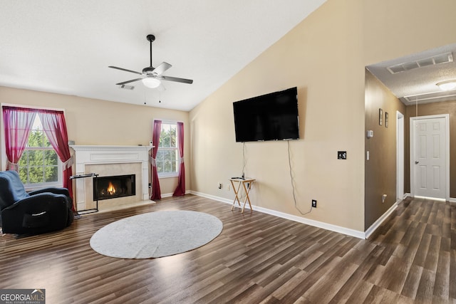 living room featuring a premium fireplace, dark hardwood / wood-style floors, and a wealth of natural light