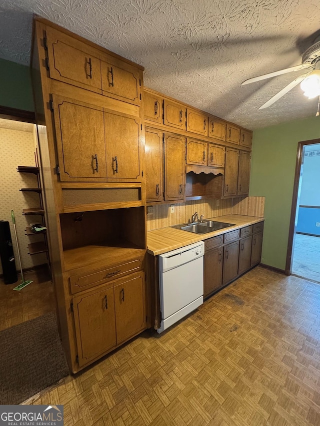 kitchen with sink, dishwasher, a textured ceiling, ceiling fan, and light parquet floors