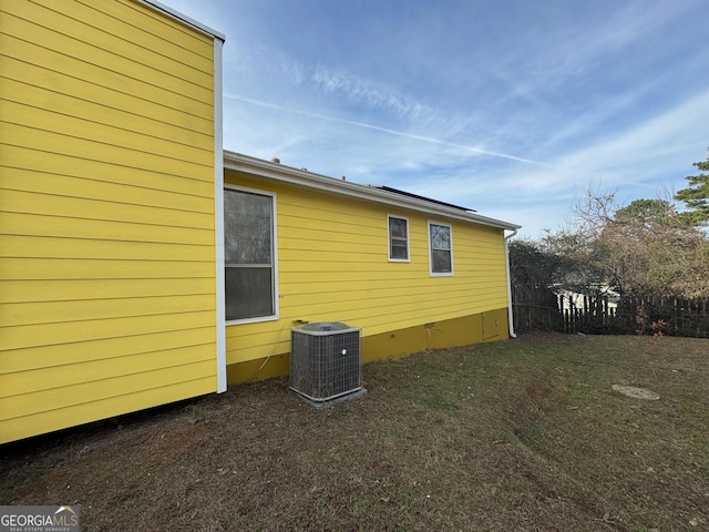 view of home's exterior featuring central AC unit and a yard