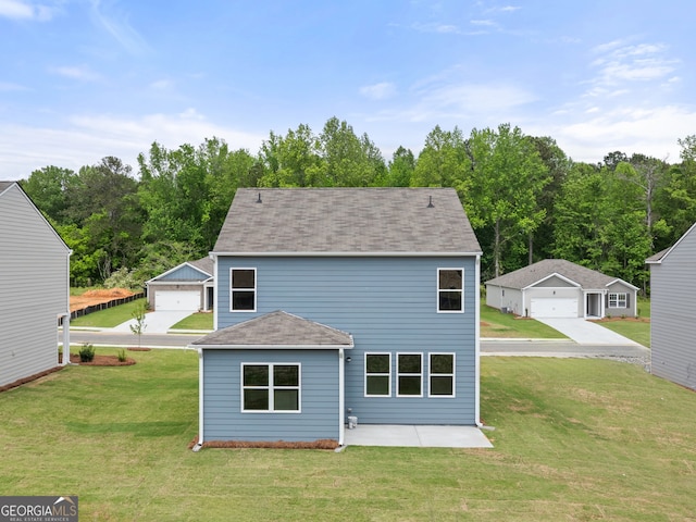 back of property featuring a yard, an outbuilding, a patio, and a shingled roof