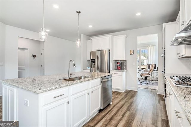 kitchen featuring appliances with stainless steel finishes, a center island with sink, white cabinets, pendant lighting, and sink