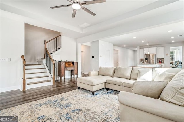 living room with dark hardwood / wood-style flooring and ceiling fan