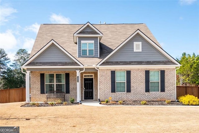 craftsman house featuring covered porch and a front lawn