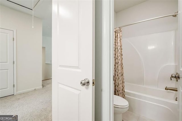 bathroom featuring shower / bathtub combination with curtain and toilet