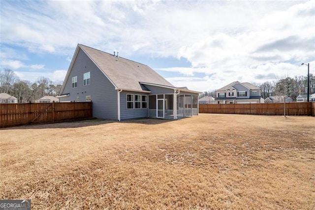 back of property with a sunroom and a lawn