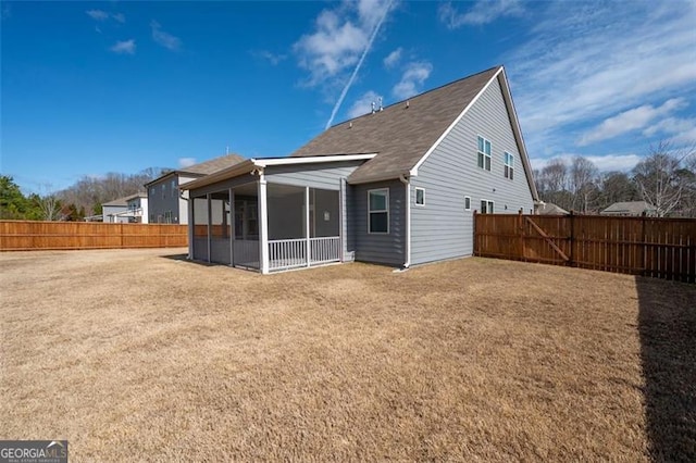 back of house with a lawn and a sunroom