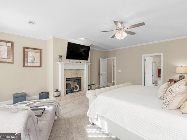 carpeted bedroom featuring a tiled fireplace, ceiling fan, and ornamental molding