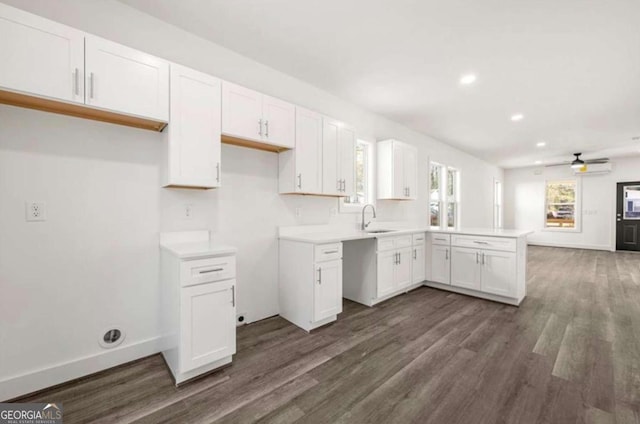 kitchen featuring sink, dark hardwood / wood-style floors, ceiling fan, kitchen peninsula, and white cabinets