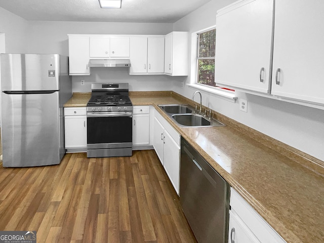 kitchen with exhaust hood, stainless steel appliances, white cabinets, dark hardwood / wood-style flooring, and sink