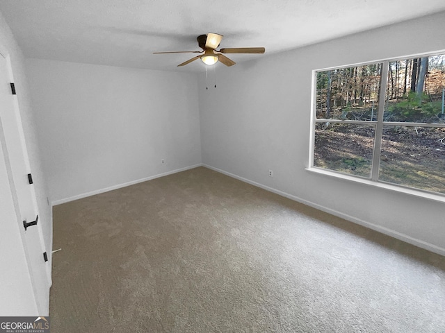 carpeted spare room featuring ceiling fan and a wealth of natural light
