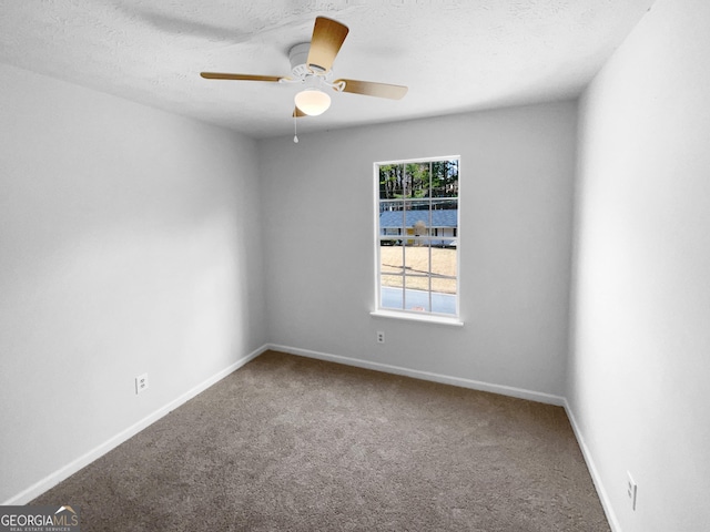 carpeted spare room with ceiling fan and a textured ceiling