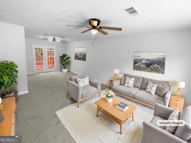 living room with a textured ceiling, french doors, light carpet, and ceiling fan