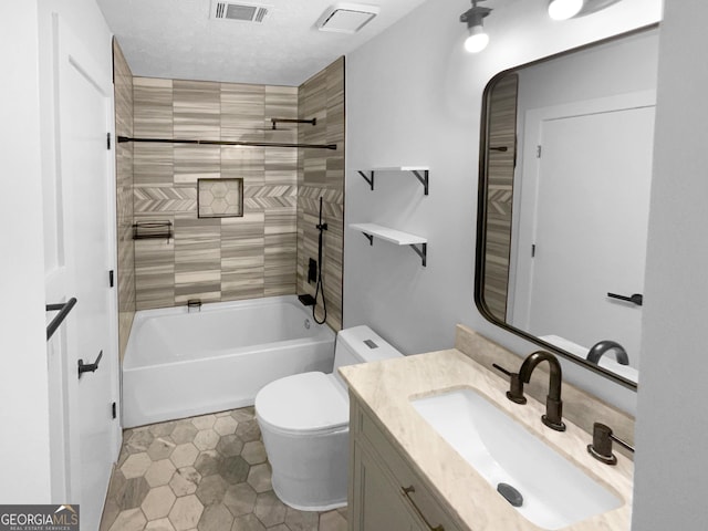 full bathroom with tiled shower / bath combo, vanity, toilet, and a textured ceiling
