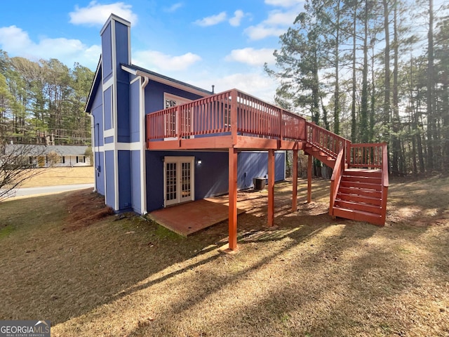 view of play area with a yard, french doors, and a wooden deck