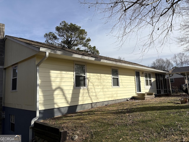 rear view of property featuring a lawn