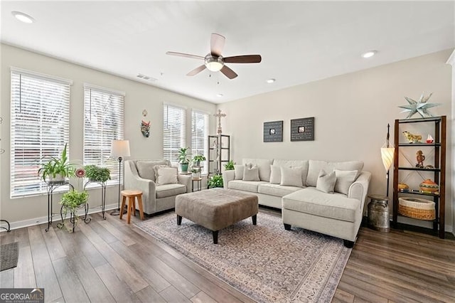 living room featuring ceiling fan and dark hardwood / wood-style floors