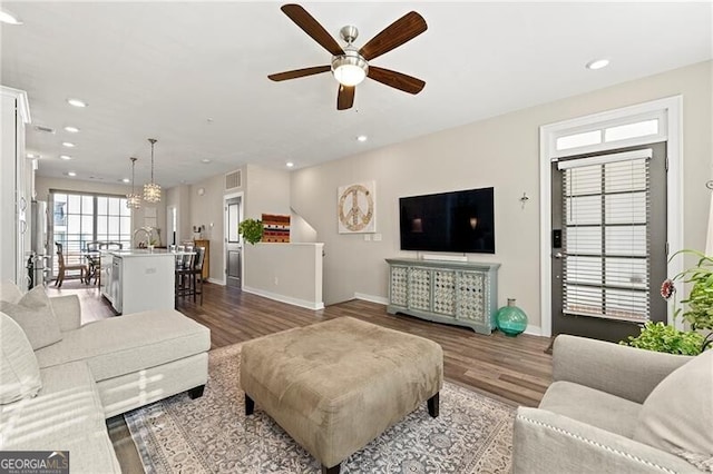 living room with ceiling fan and dark hardwood / wood-style floors