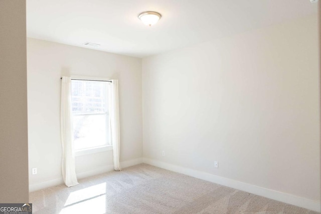 empty room with light colored carpet, visible vents, and baseboards