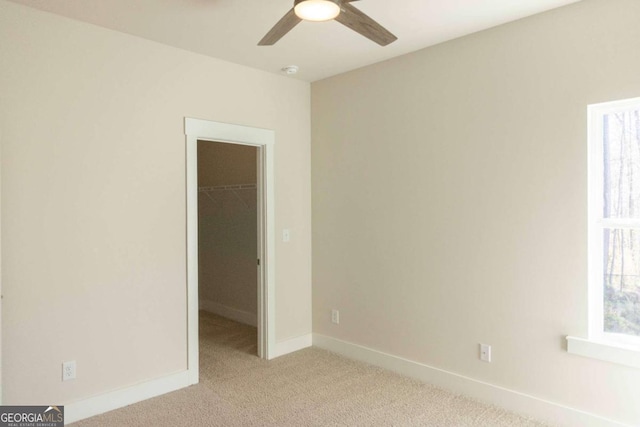unfurnished room with ceiling fan, baseboards, and light carpet