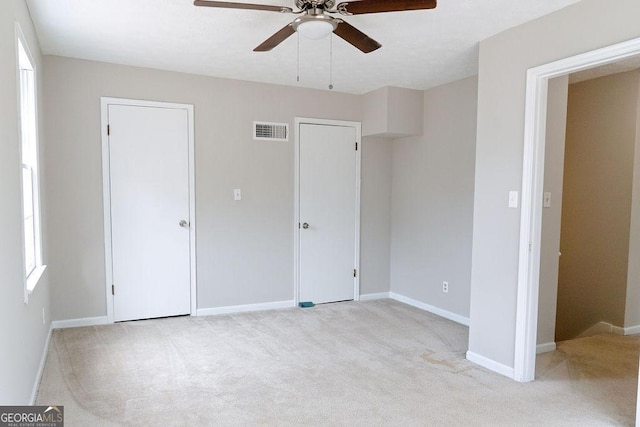 unfurnished bedroom with light carpet and ceiling fan