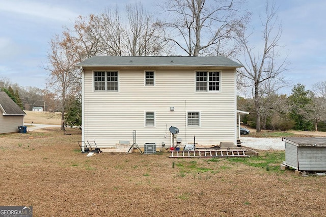 back of property with a lawn and central air condition unit