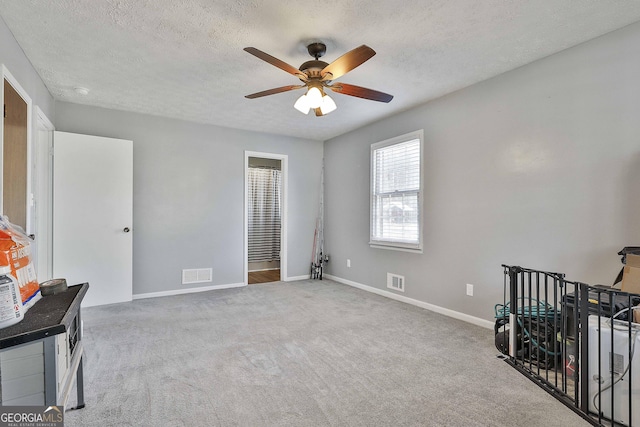 interior space with a textured ceiling and ceiling fan