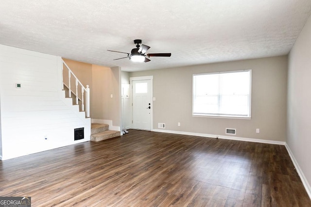 unfurnished living room with a textured ceiling, dark wood-type flooring, and ceiling fan